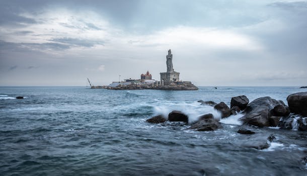 pexels-photo-25811351-25811351 Scenic view of Thiruvalluvar Statue in Kanniyakumari at sunrise, surrounded by ocean waves.